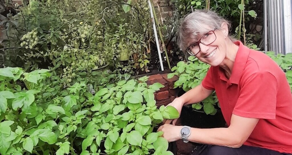 Woman in red top tending plants in a garden, representing a consistent visual identity