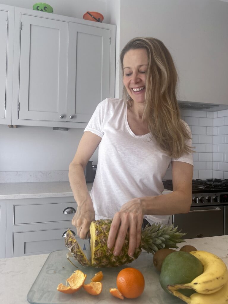 Menopause coach preparing fresh fruit in her kitchen during a virtual brand photo shoot