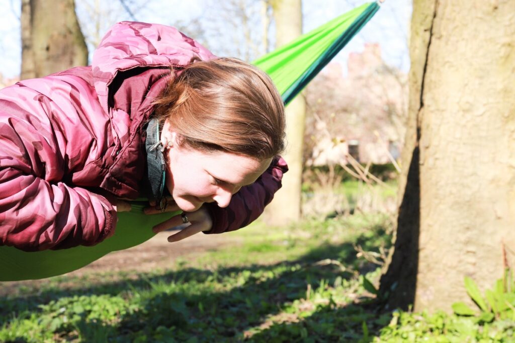 Woman relaxing outdoors in a hammock surrounded by trees during a virtual brand photo shoot