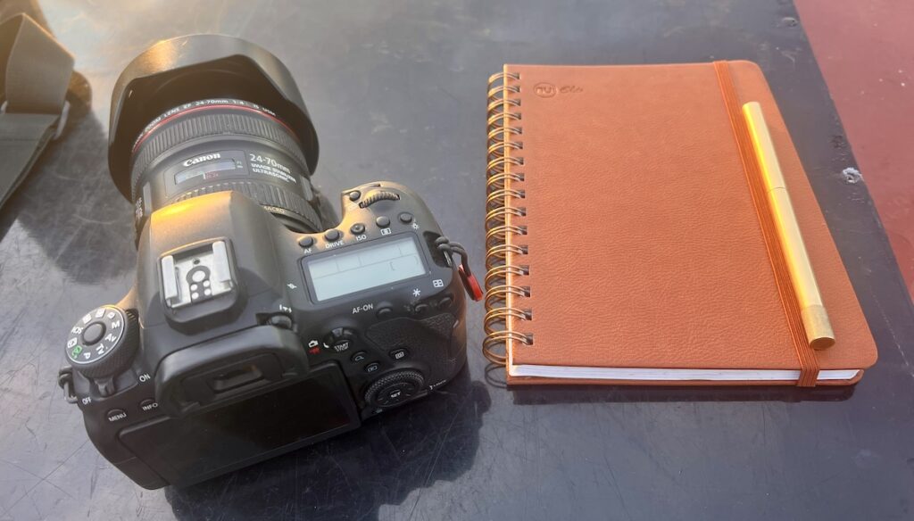 Camera and notebook used to plan thoughtful brand photography sessions.